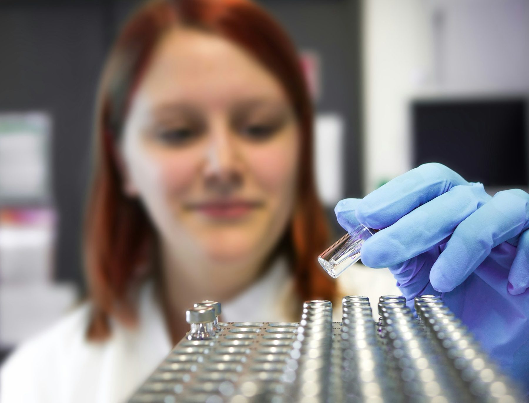 A scientist handling sample vials